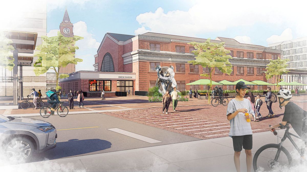 Drawing showing an updated plaza and canopy at the International District Station along 5th Ave S. There is a public art installation on the plaza, an active street market, and people crossing 5th Ave S walking and on bicycles.